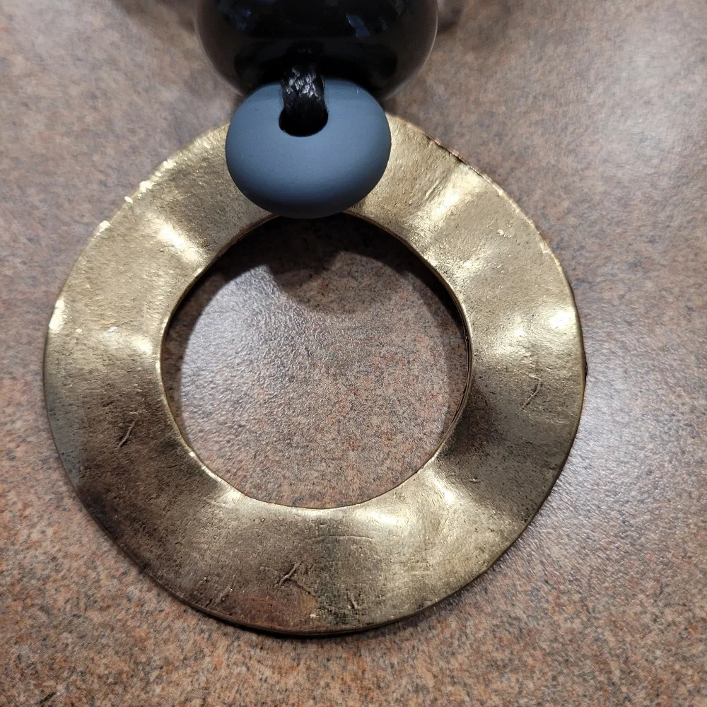 Black rope necklace with gold medal, black, and gray circle. - Picture 3 of 6